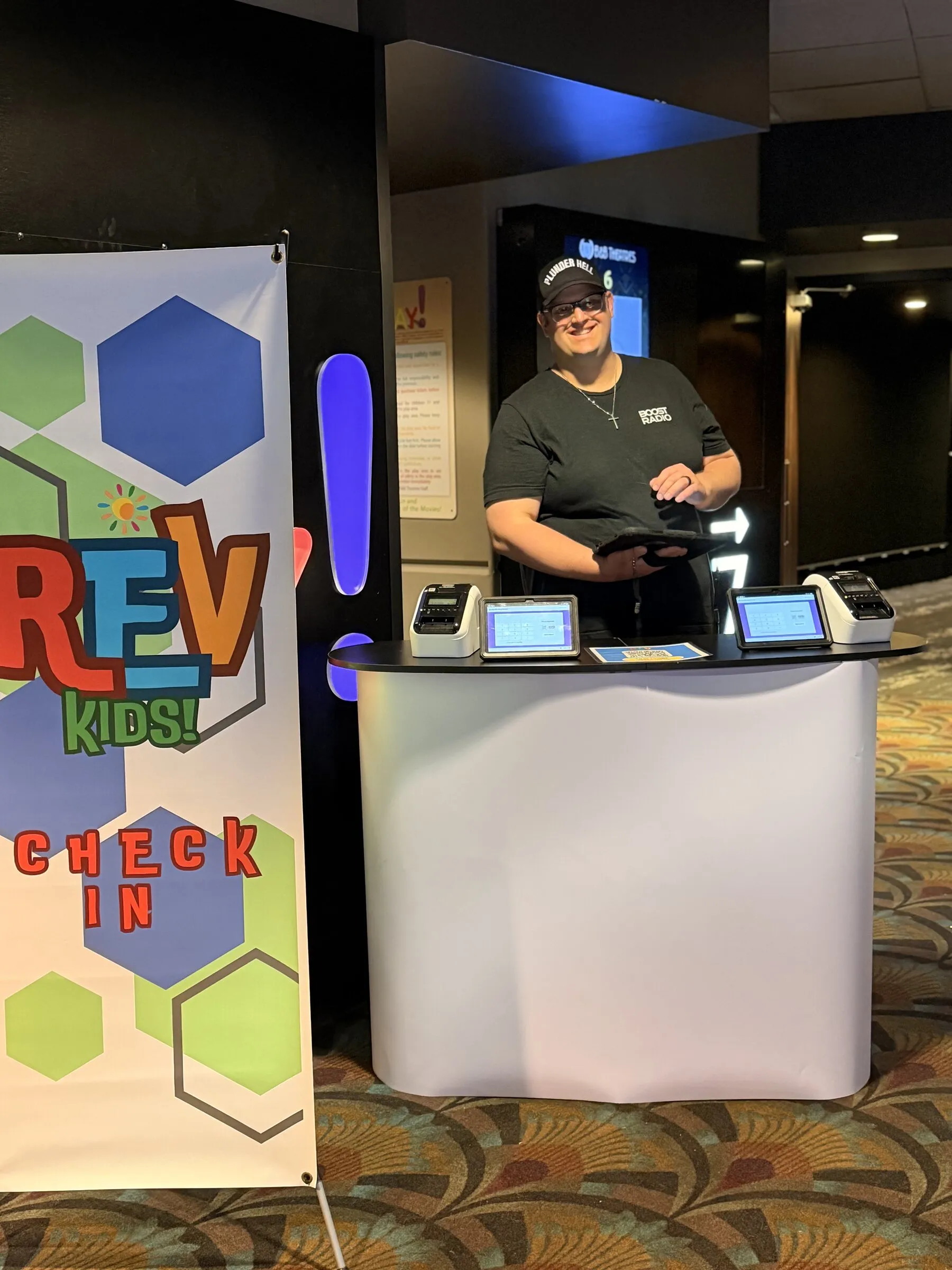 A friendly volunteer at the RevKids check-in desk